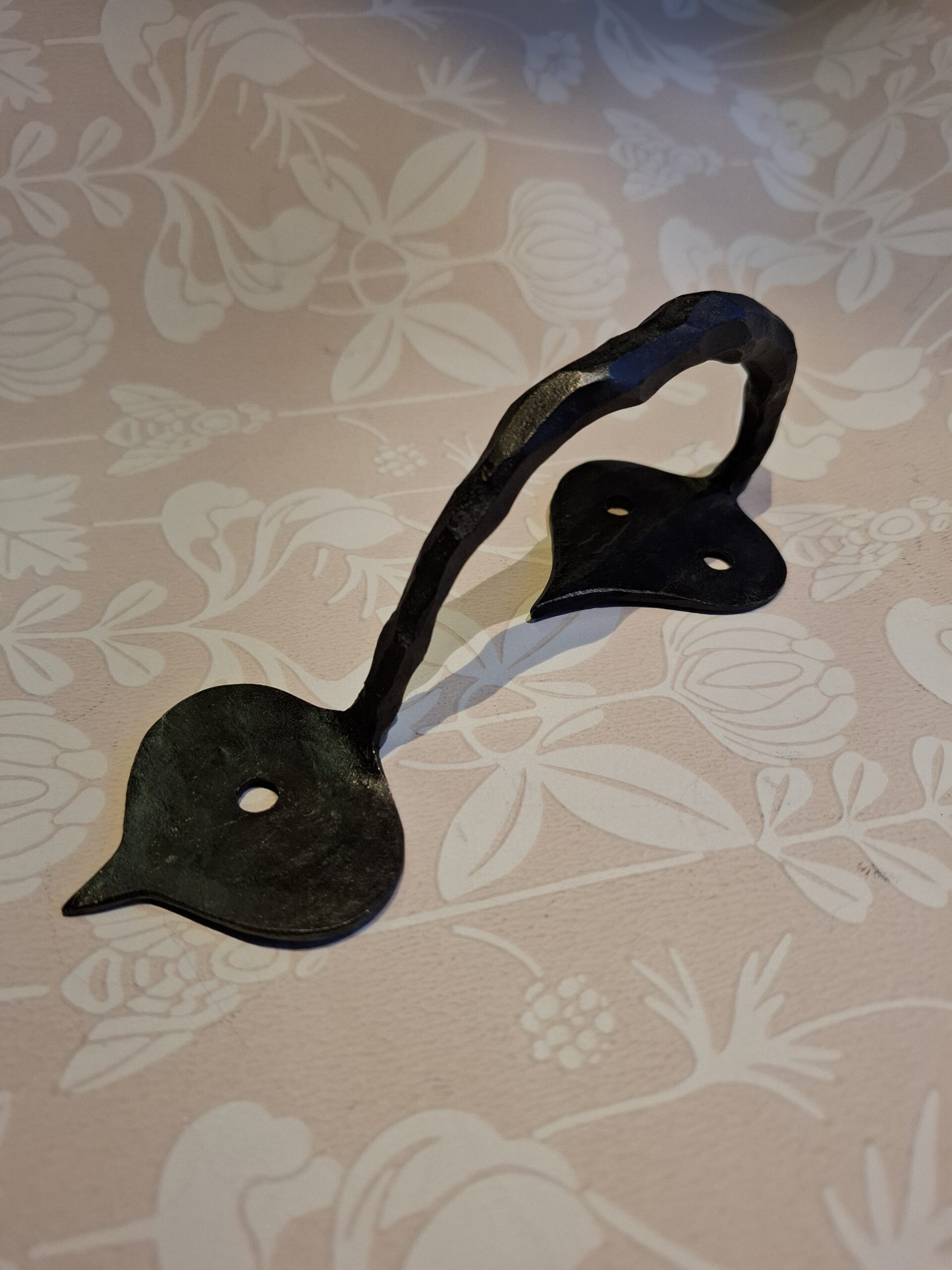 Smideshandtag rakt i traditionellt smide – ett tidstypiskt beslag för byggnadsvård och klassisk inredning.